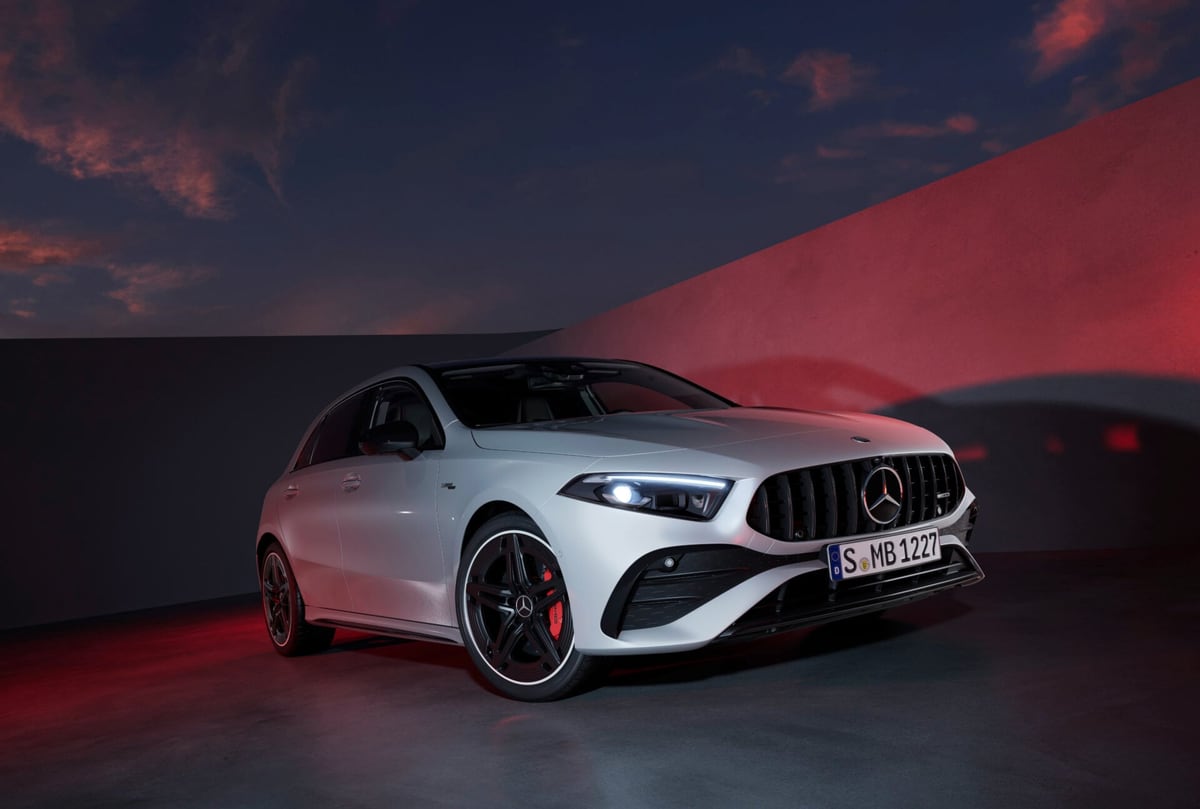 Een witte sportieve hatchback, driekwart vooraanzicht, in sfeervol avondlicht